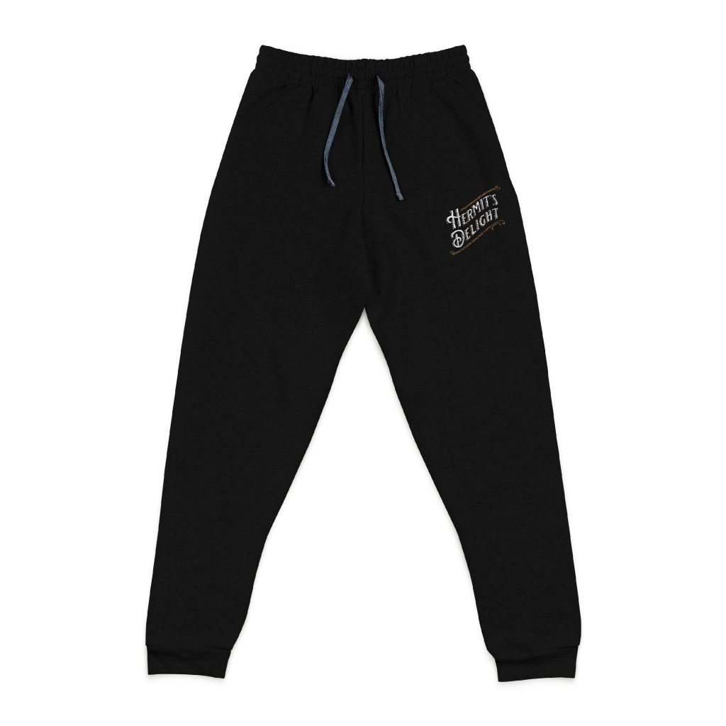 black sweatpants, hermit's delight logo embroidered on top of left leg