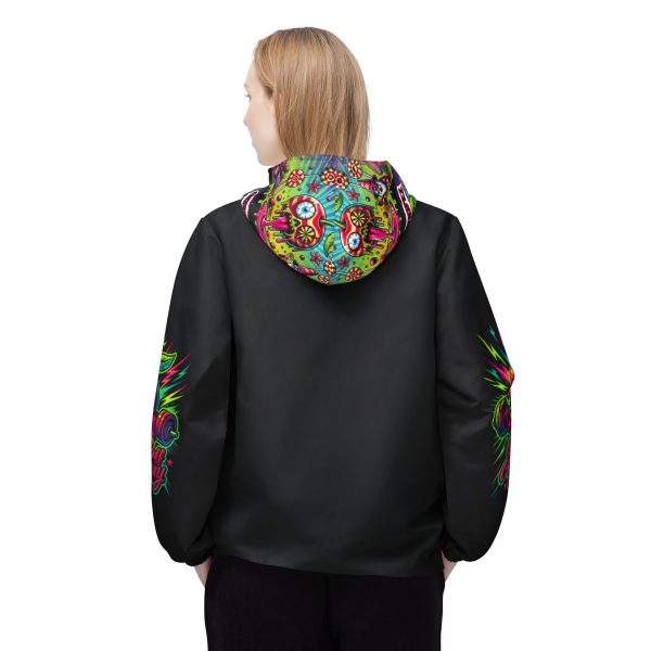 A rear view of a Black unisex windbreaker with a colorful, psychedelic design on the hood and along the outer sides of both arms. The design features bright shades of green, blue, pink, and orange. The design on the hood shows a melting skull-shaped cherry with a psychedelic eyeball, surrounded by candy, stars, and lollipops. This design is mirrored on both sides of the hood. The windbreaker has a relaxed fit with elastic cuffs.